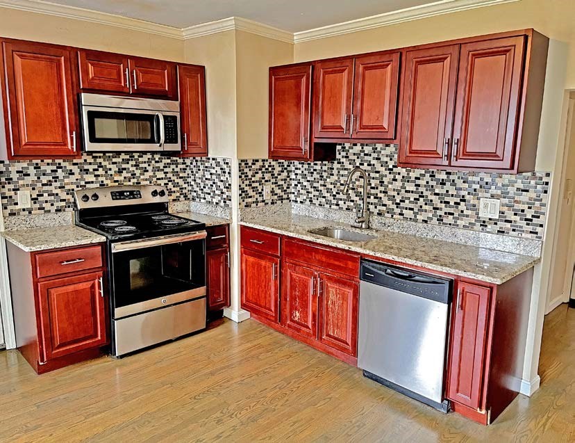 3106-3110 Washington Street Boston, MA 02119 - Photo 7 of 16 a kitchen with stainless steel appliances granite countertop a stove a sink dishwasher and microwave