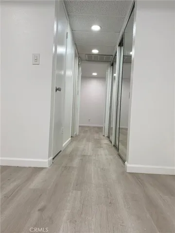 an empty room with wooden floor and mirror