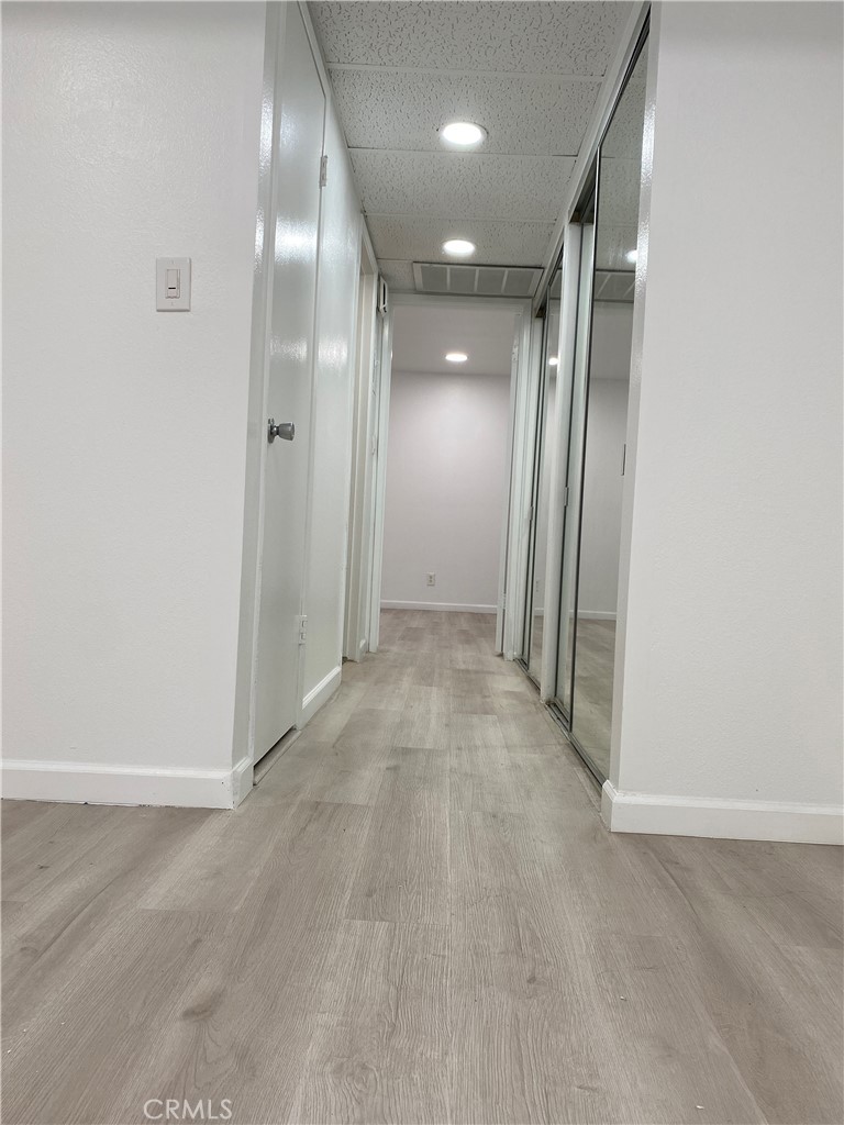18645 Hatteras Street, Unit 278 Tarzana, CA 91356 - Photo 8 of 37 an empty room with wooden floor and mirror