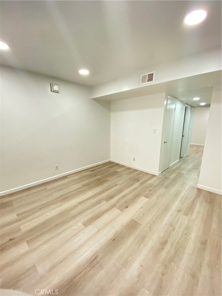 18645 Hatteras Street, Unit 278 Tarzana, CA 91356 - Photo 10 of 37 an empty room with wooden floor and windows