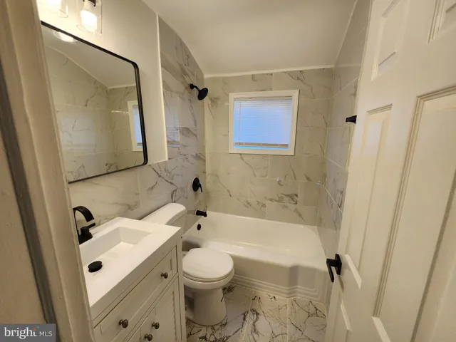 a bathroom with a sink a toilet a mirror and shower