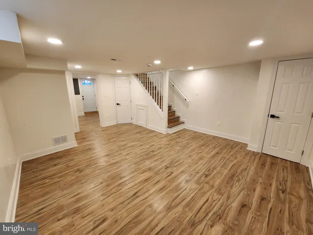 a view of an empty room with wooden floor
