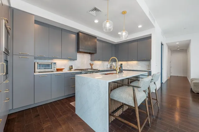 a kitchen with kitchen island a sink appliances and cabinets