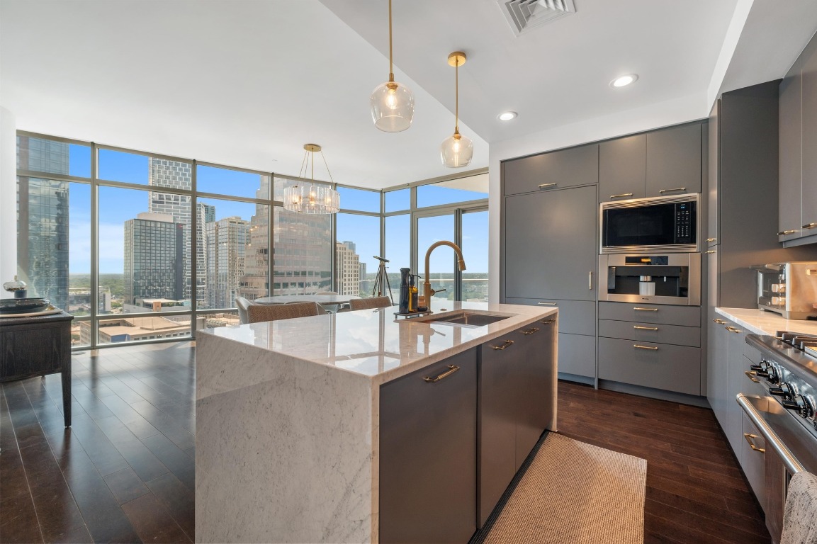 200 Congress Avenue, Unit 19F Austin, TX 78701 - Photo 13 of 40 a kitchen with kitchen island a sink appliances and cabinets