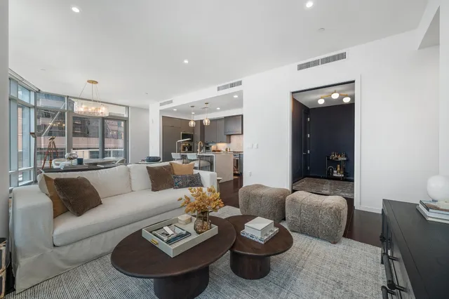 a spacious bedroom with a large bed and a chandelier