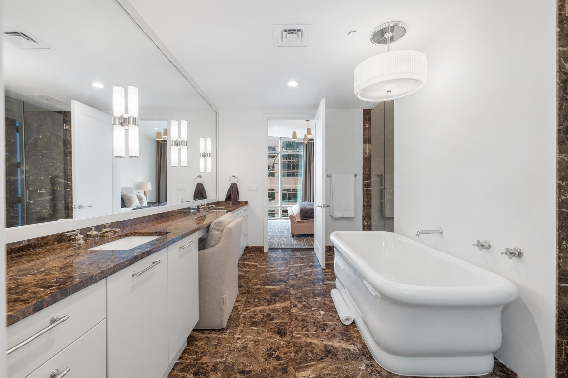 200 Congress Avenue, Unit 19F Austin, TX 78701 - Photo 22 of 40 a spacious bathroom with a bathtub sink and mirror