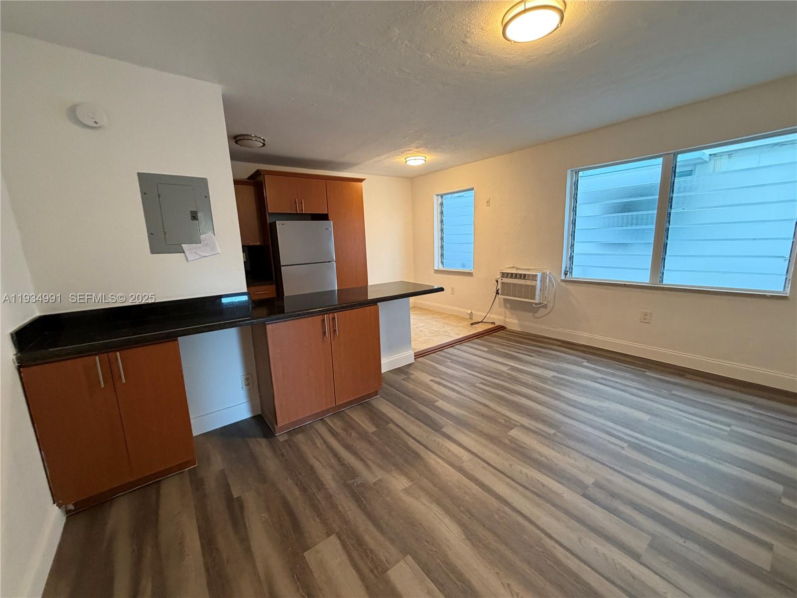 7928 Harding Avenue, Unit 1 Miami Beach, FL 33141 - Photo 2 of 12 an empty room with wooden floor and windows
