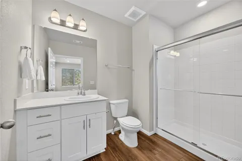 a bathroom with a sink a toilet a mirror and shower