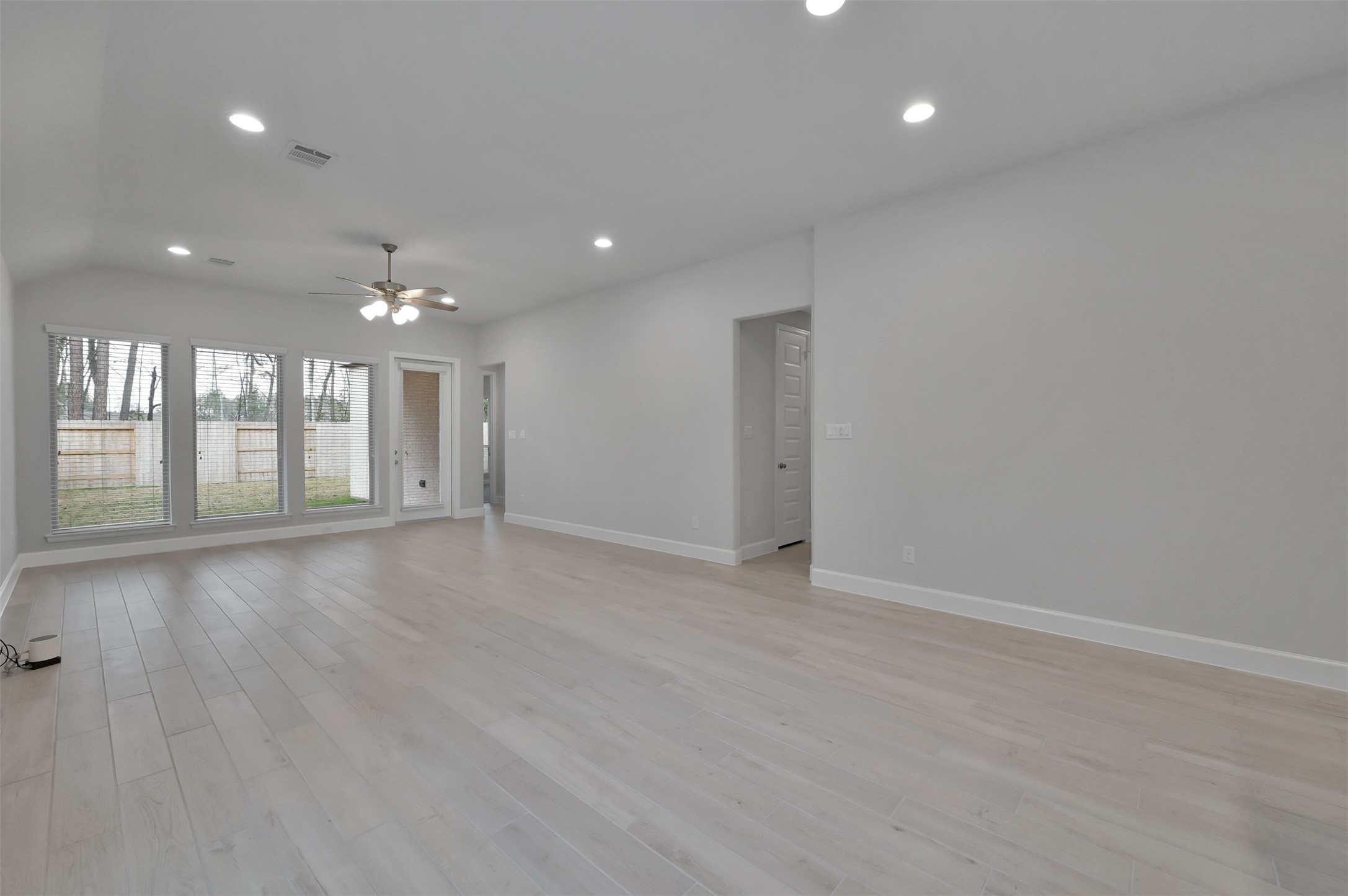 15715 Autumn Sun Conroe, TX 77302 - Photo 9 of 23 an empty room with wooden floor and windows