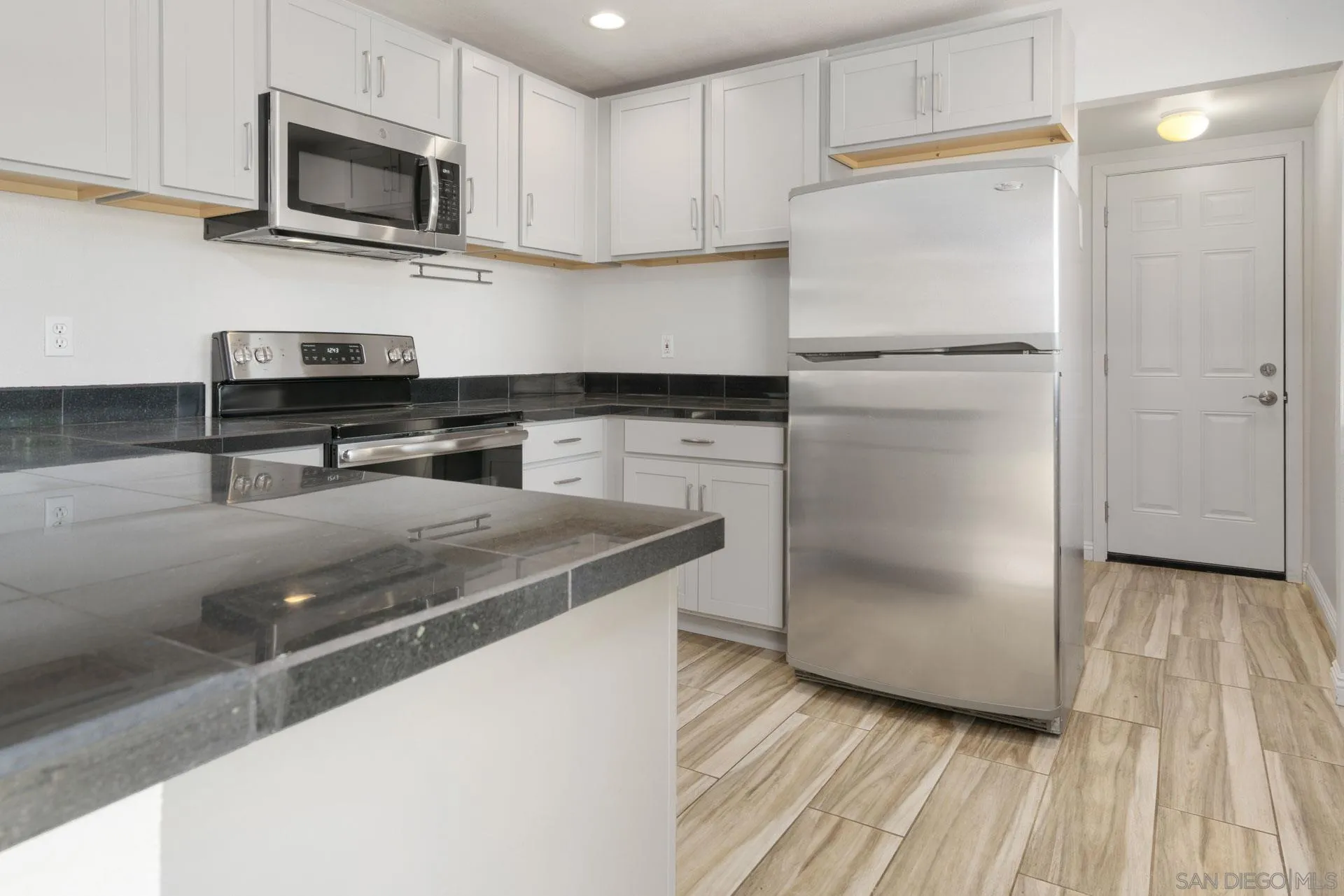 913 Buena Rosa Court Fallbrook, CA 92028 - Photo 12 of 45 a kitchen with a refrigerator and a stove top oven