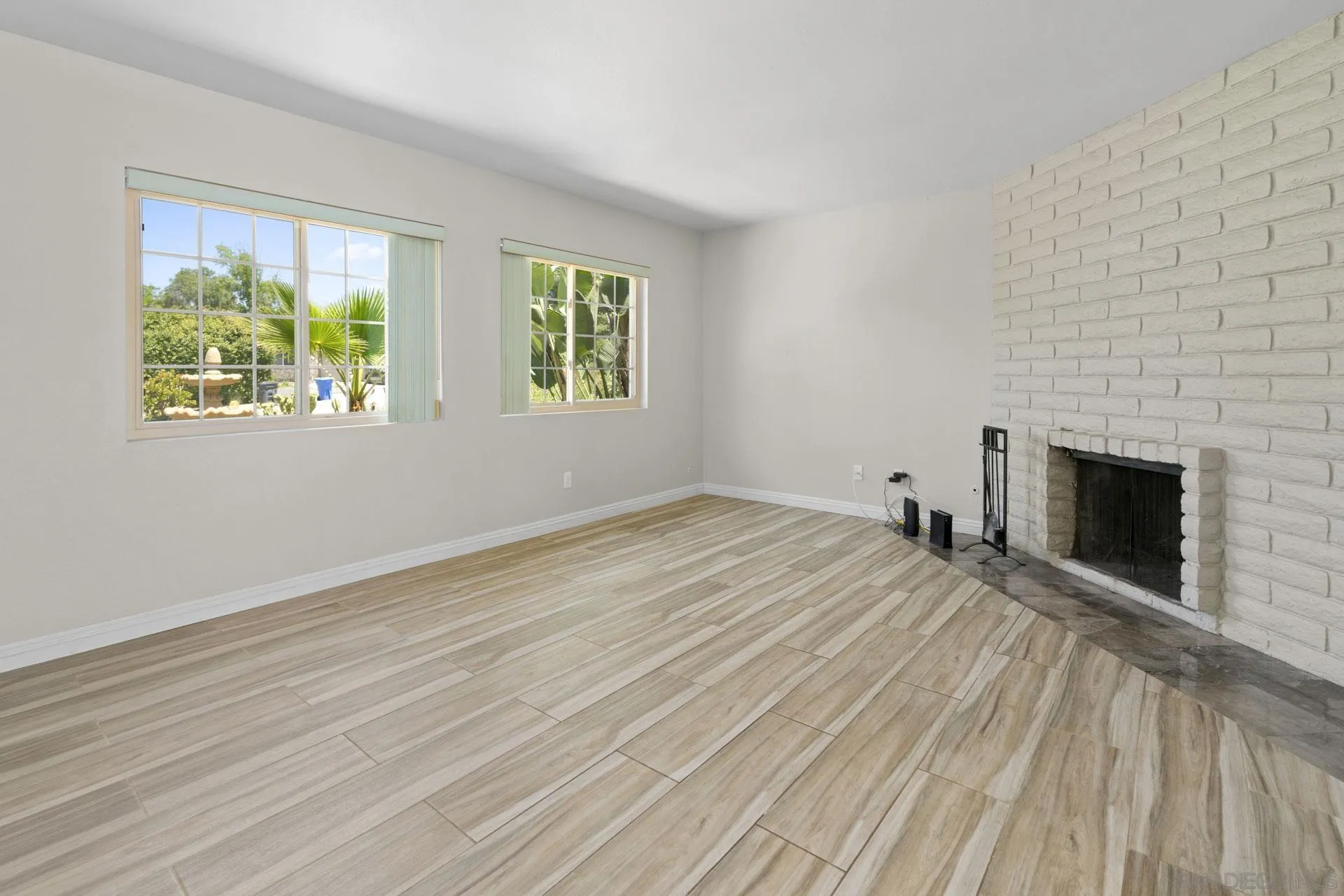 913 Buena Rosa Court Fallbrook, CA 92028 - Photo 6 of 45 a view of empty room with wooden floor and fireplace