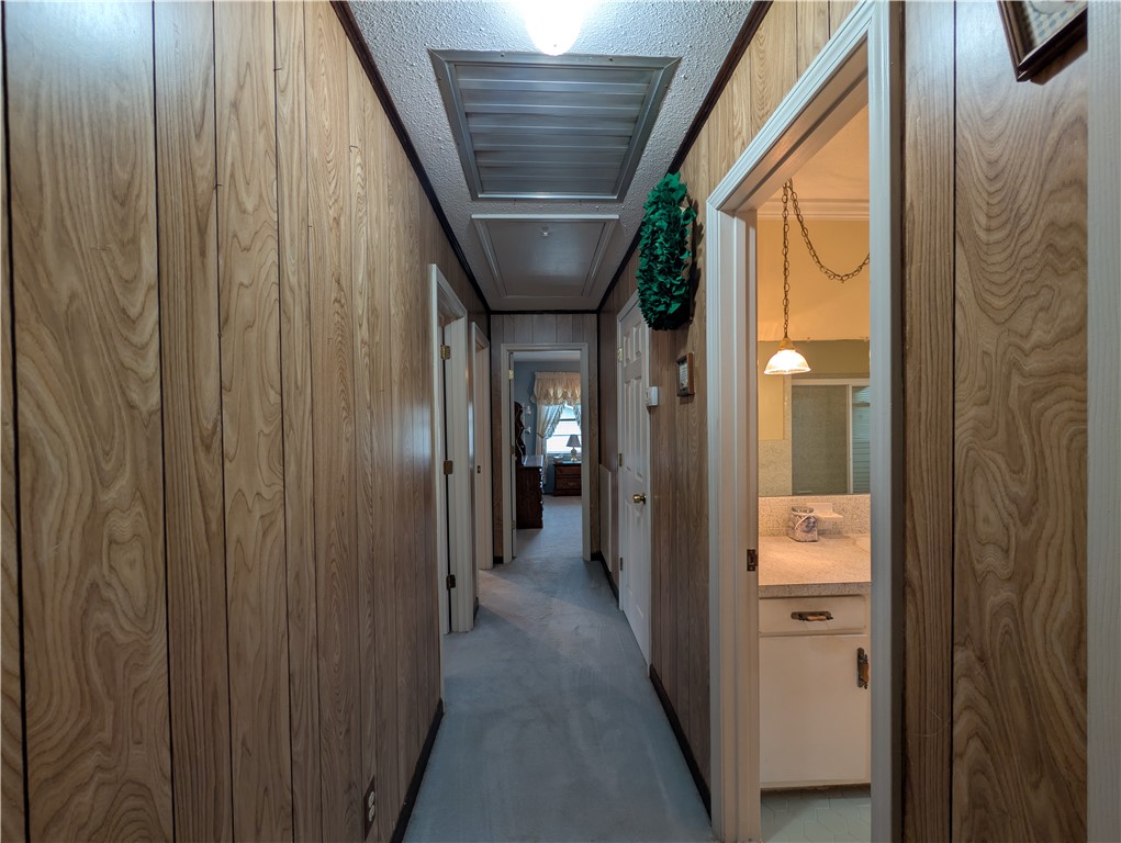 1000 Hickory Lane Anderson, SC 29624 - Photo 7 of 37 This interior hallway features classic wood paneling and leads to other rooms within the home.