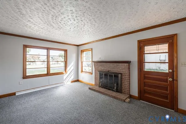 an empty room with fireplace cabinet and windows