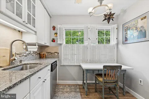 a kitchen with granite countertop white cabinets and stainless steel appliances