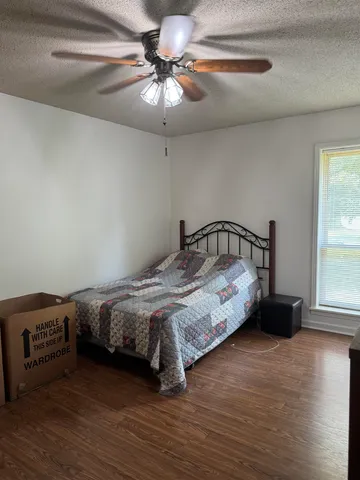 a bedroom with a bed and wooden floor