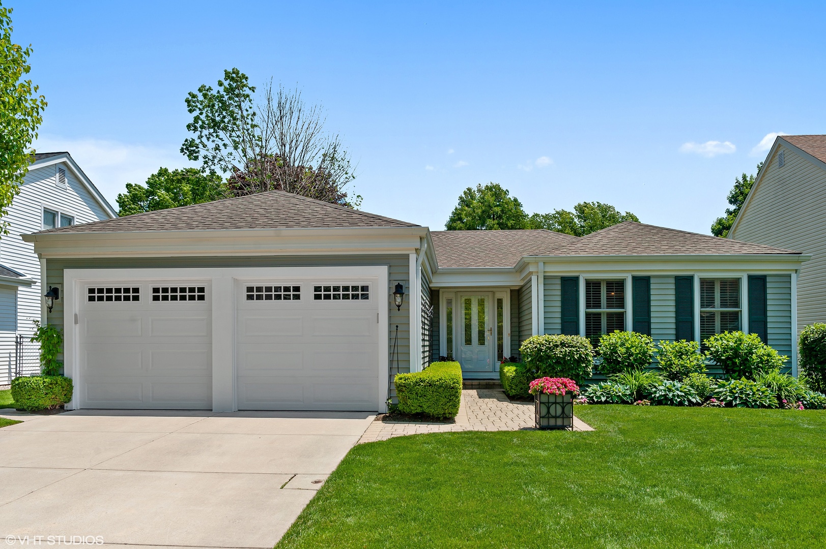 a front view of a house with a garden and plants