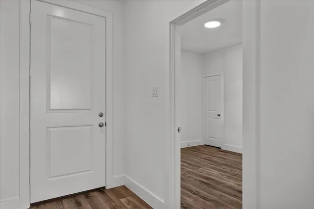 a view of a hallway with wooden floor