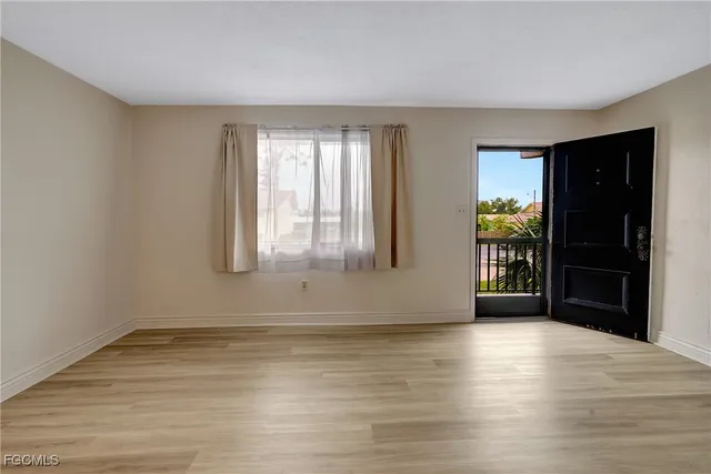 a view of a livingroom with a flat screen tv wooden floor and a window