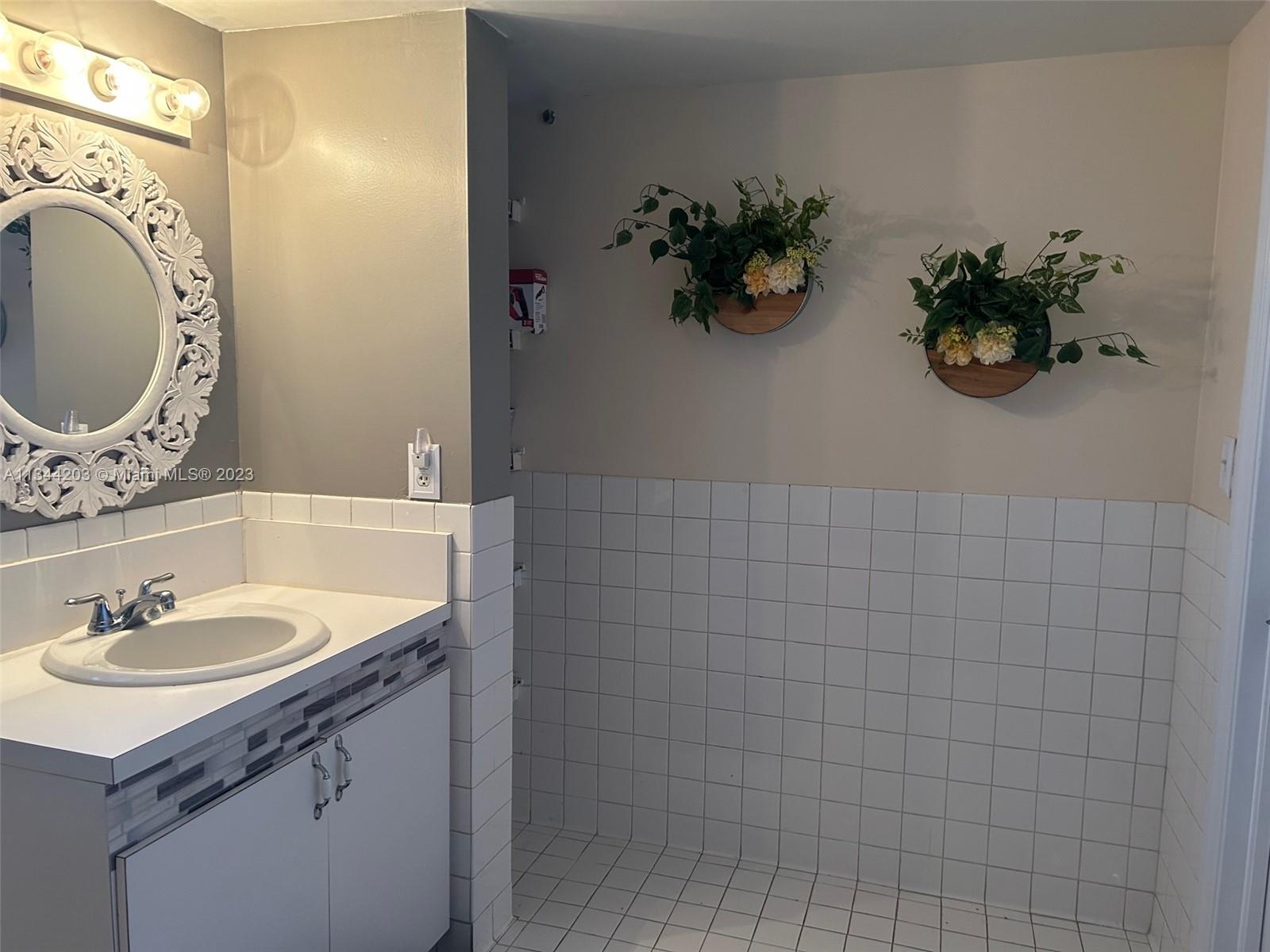 55 East 4th Street, Unit 302 Hialeah, FL 33010 - Photo 14 of 17 a bathroom with a sink toilet and a mirror
