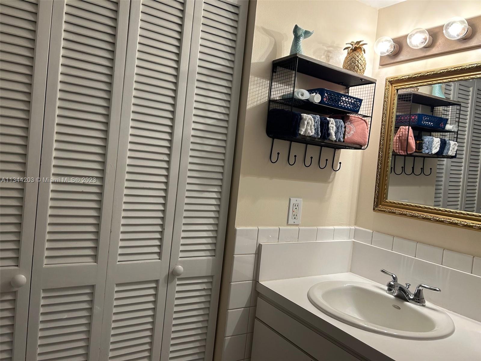 55 East 4th Street, Unit 302 Hialeah, FL 33010 - Photo 15 of 17 a bathroom with a sink and a mirror