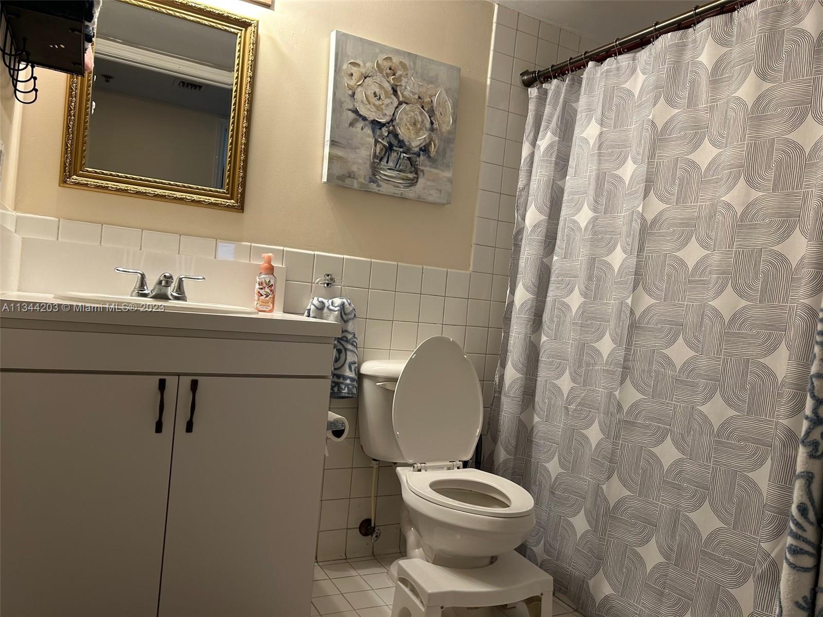 55 East 4th Street, Unit 302 Hialeah, FL 33010 - Photo 16 of 17 a bathroom with a toilet sink and mirror