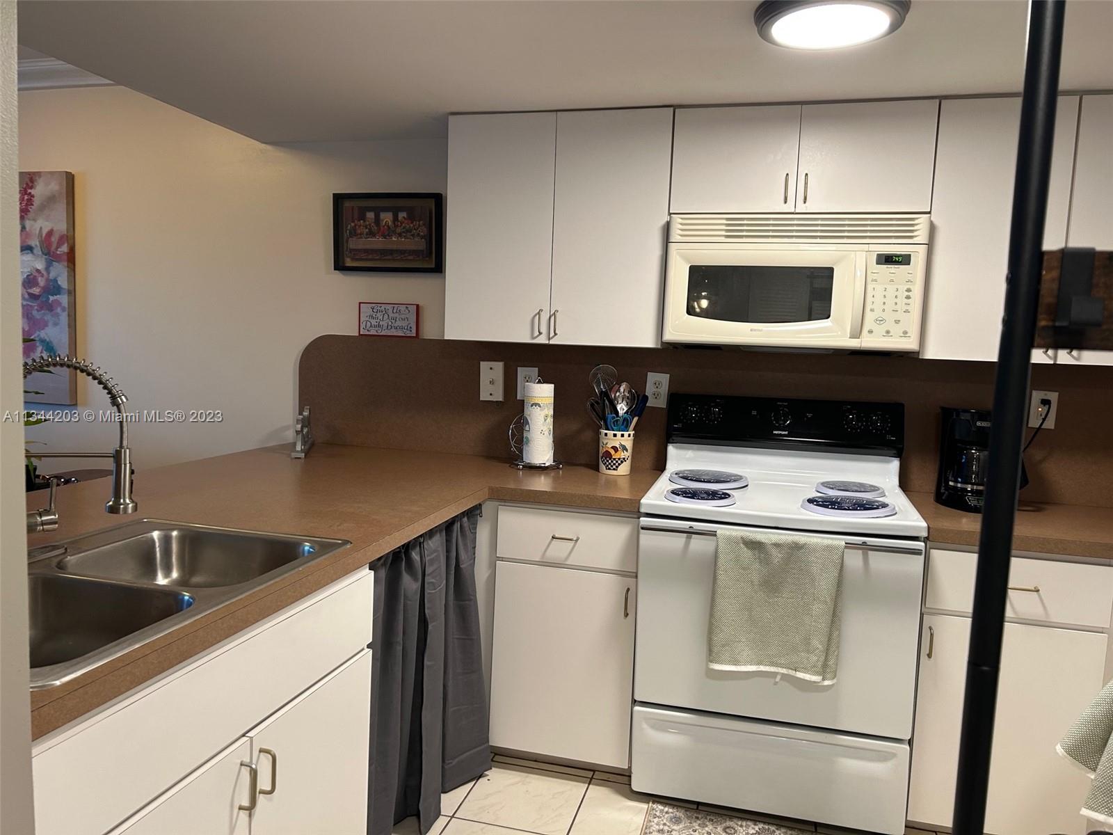 55 East 4th Street, Unit 302 Hialeah, FL 33010 - Photo 3 of 17 a kitchen with a stove and a sink