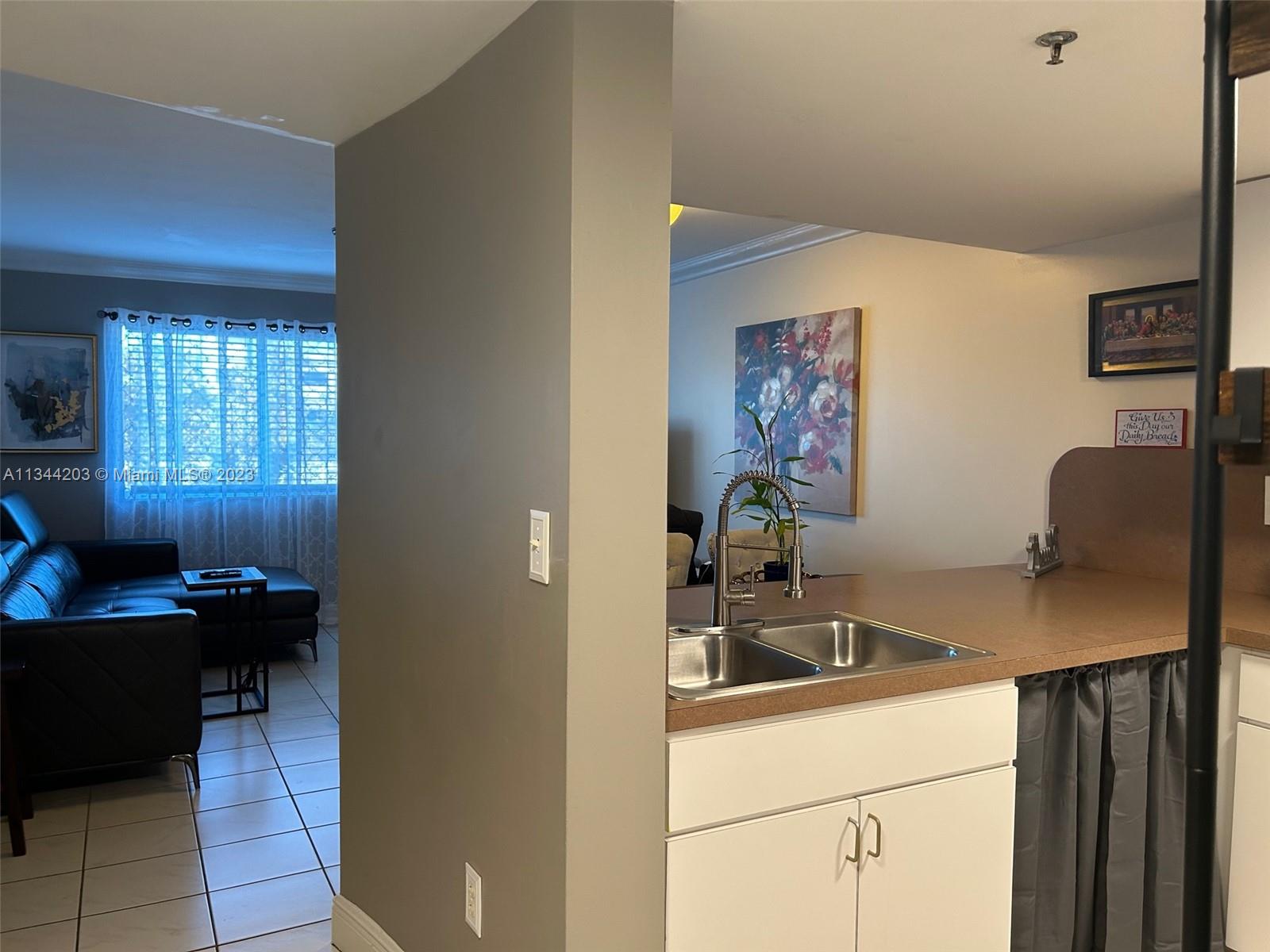 55 East 4th Street, Unit 302 Hialeah, FL 33010 - Photo 4 of 17 a kitchen with a sink cabinets and a window