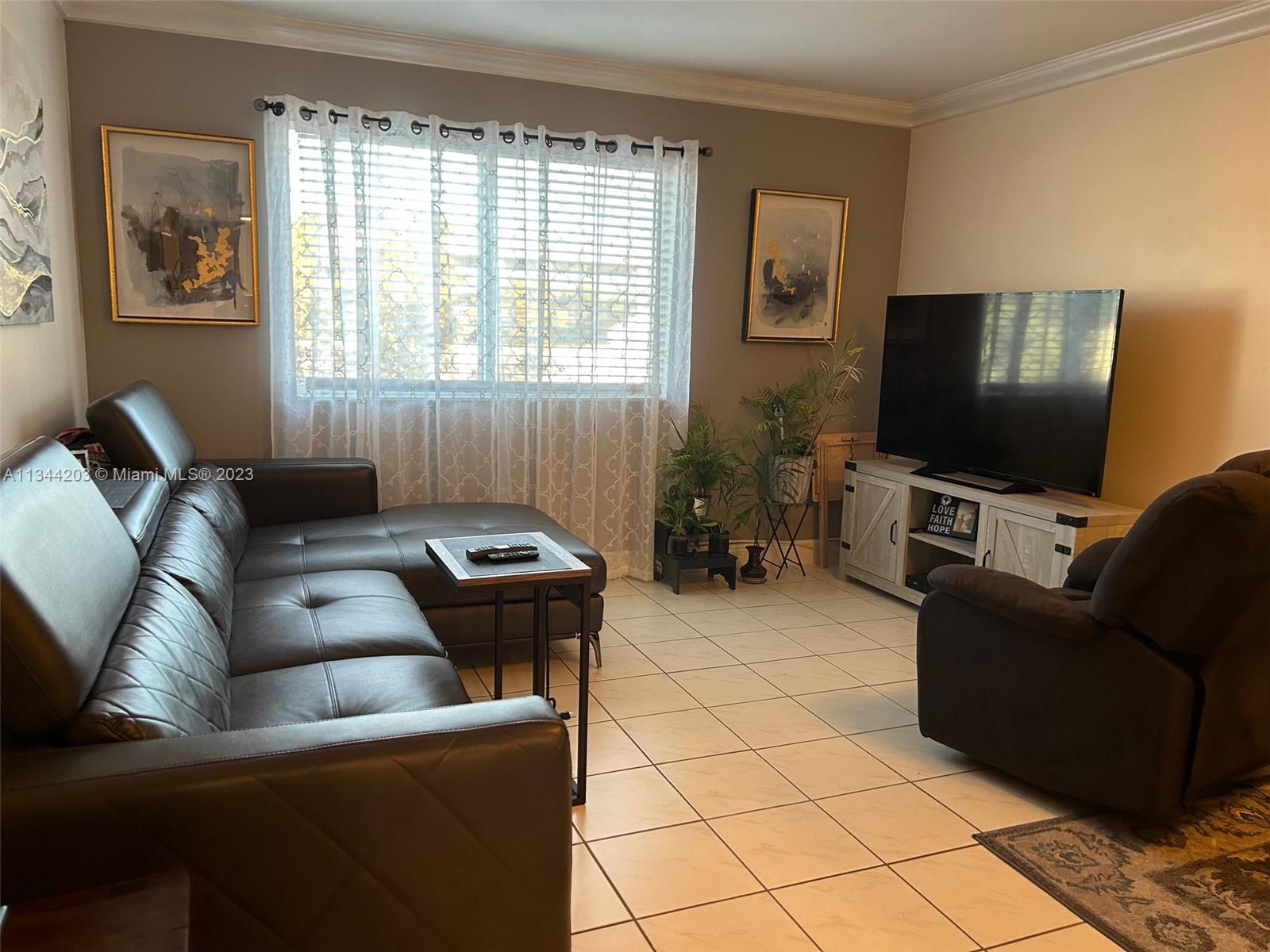 55 East 4th Street, Unit 302 Hialeah, FL 33010 - Photo 5 of 17 a living room with furniture and a flat screen tv