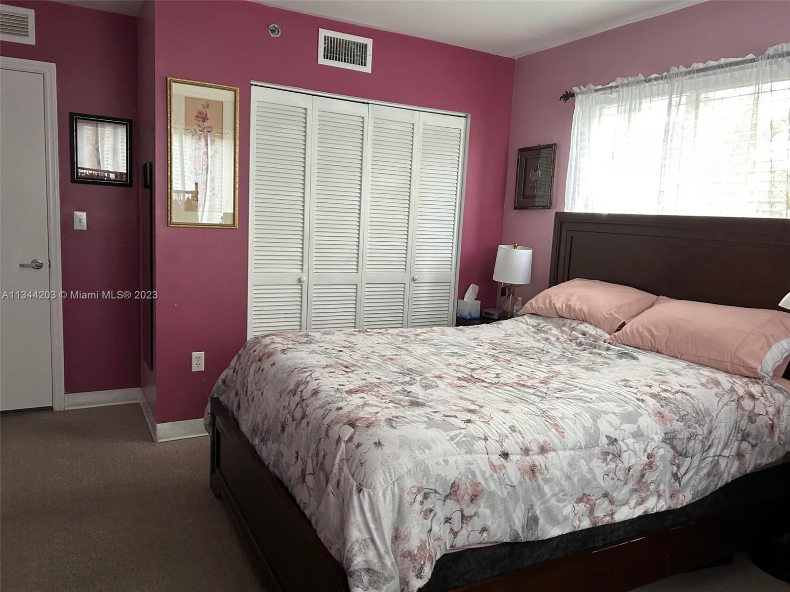 55 East 4th Street, Unit 302 Hialeah, FL 33010 - Photo 8 of 17 a bed sitting in a bedroom next to a window