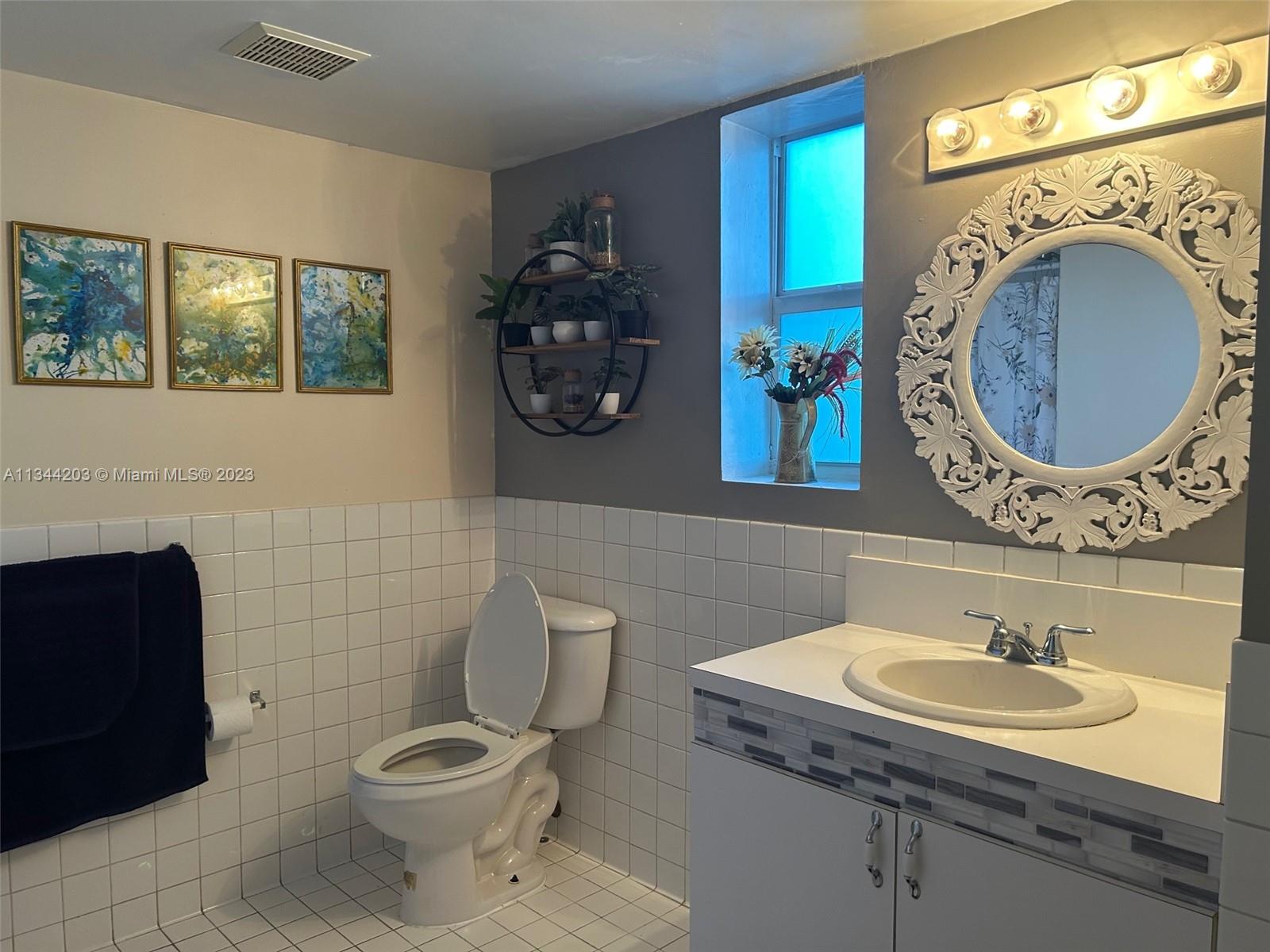 55 East 4th Street, Unit 302 Hialeah, FL 33010 - Photo 10 of 17 a bathroom with a toilet a sink and a mirror