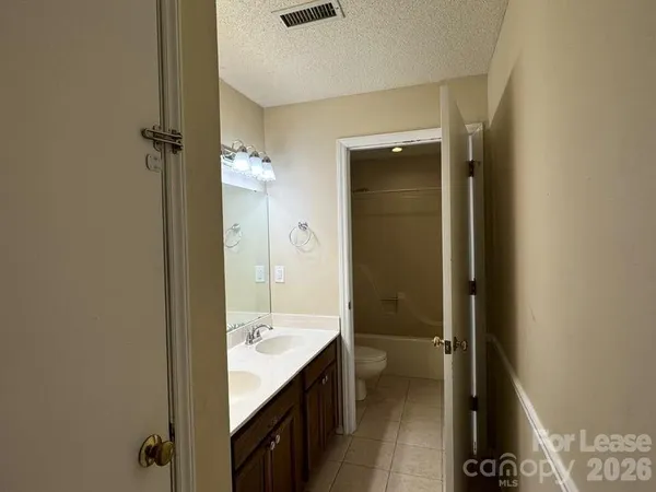 a bathroom with a granite countertop sink a mirror and shower
