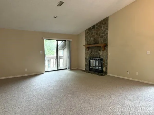 an empty room with a fireplace and window