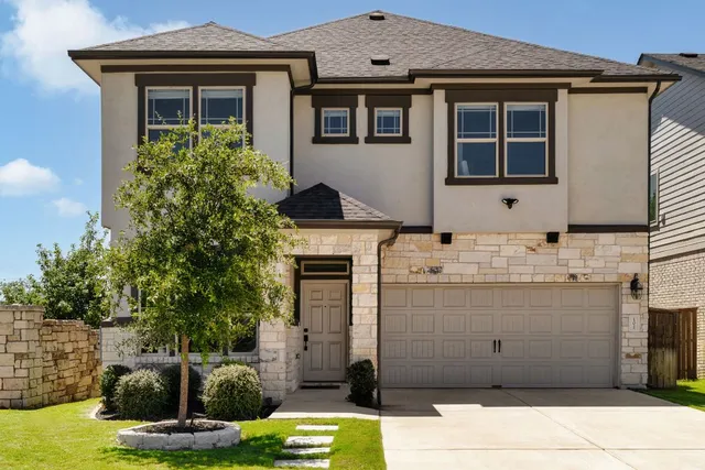 a view of a house with a small yard and potted plants