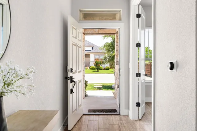 hallway view with wooden floor and a door
