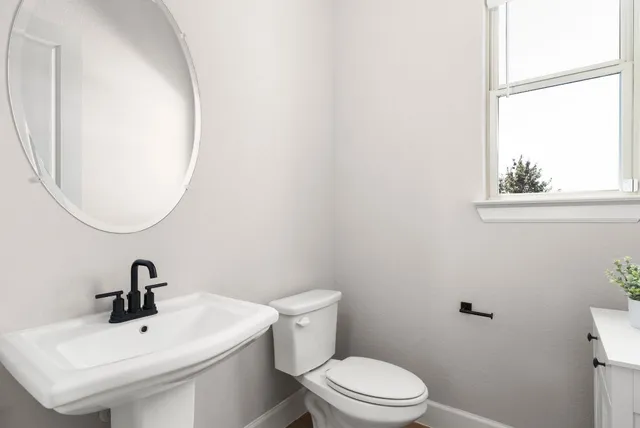 a white toilet sitting next to a bathroom sink
