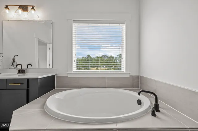 a bathroom with a sink a mirror and a bathtub