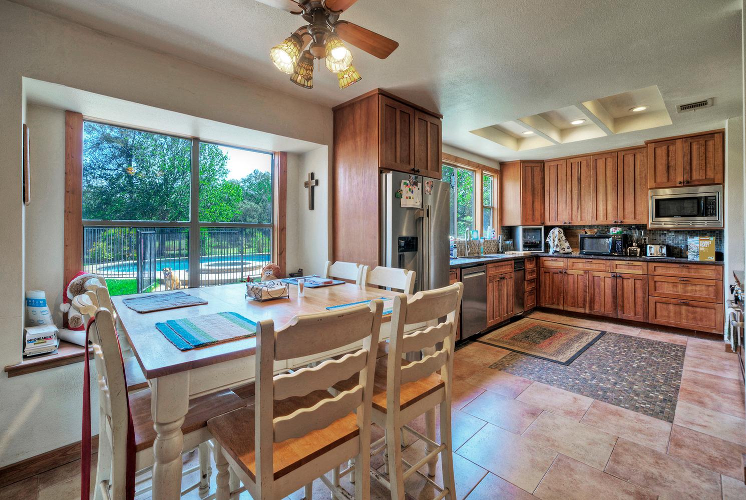 2300 Robin Road Manchaca, TX 78652 - Photo 12 of 36 Natural light streams through large windows into this spacious kitchen with warm wood cabinetry.