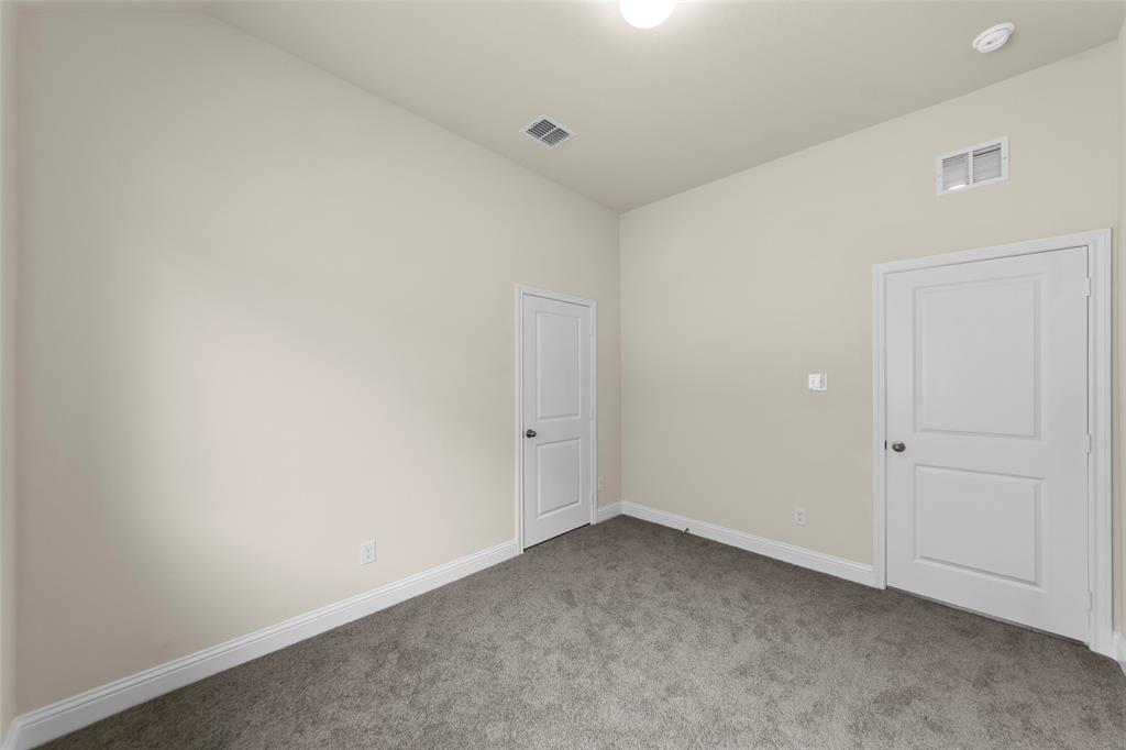 1508 Addison Lane Lancaster, TX 75134 - Photo 15 of 20 Neutral-toned room featuring a dark gray carpet, white baseboards, and two white paneled doors