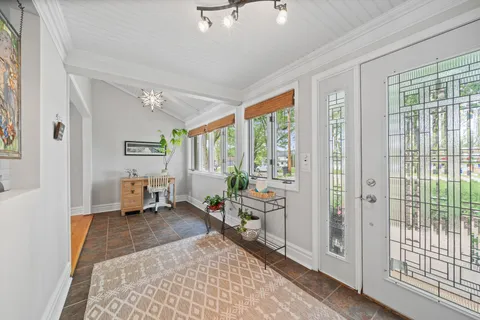 a living room with furniture floor to ceiling window and wooden floor