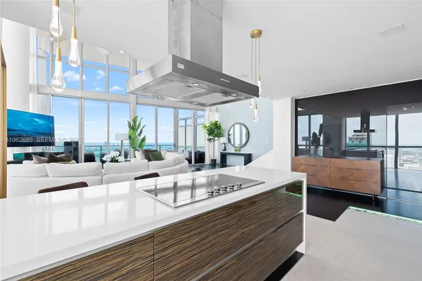 a living room with furniture a flat screen tv and a floor to ceiling window