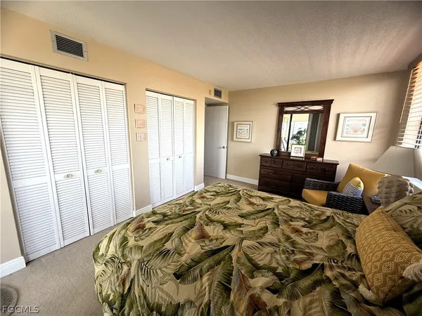 a view of a swimming pool with lawn chairs and plants