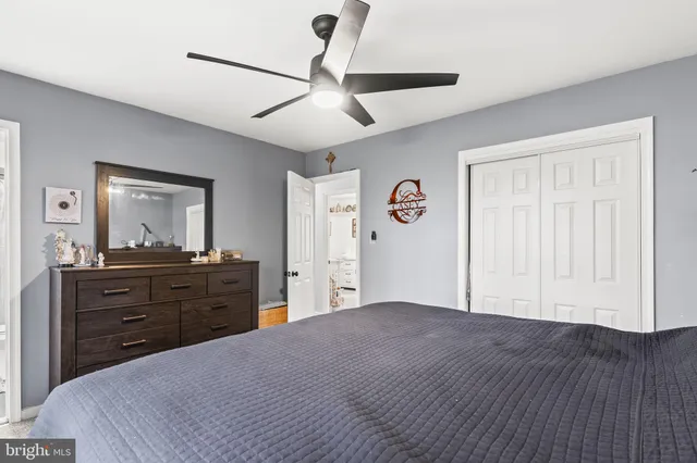 a bedroom with a bed and a mirror on the dresser