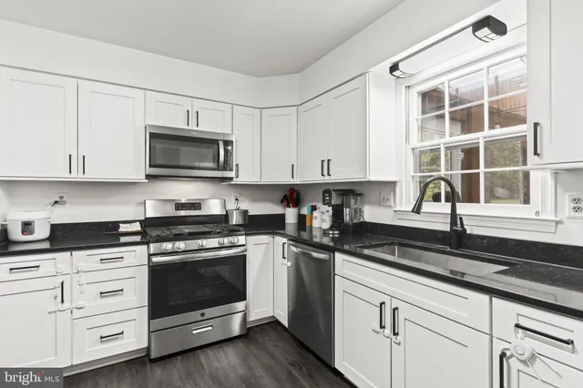 a kitchen with white cabinets and appliances