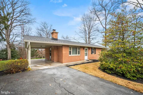 a view of a house with a yard and large tree