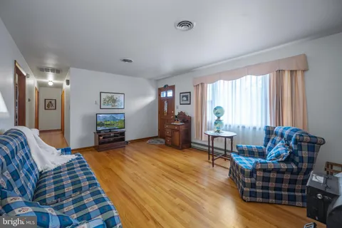 a living room with furniture and a wooden floor