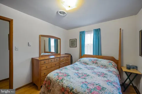 a bedroom with a bed and dresser with mirror