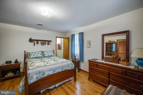 a bedroom with a bed and a large mirror on dresser
