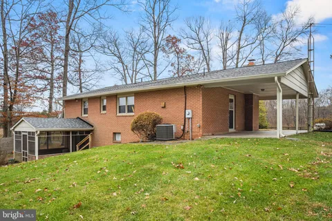 a view of a house with a yard and sitting area