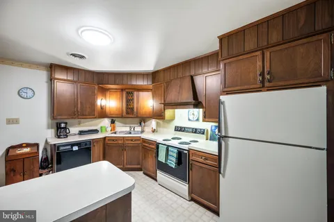 a kitchen with stainless steel appliances granite countertop a refrigerator a sink dishwasher a stove and a refrigerator