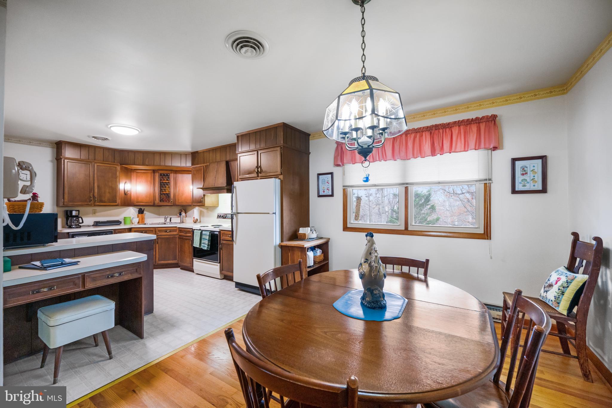 5402 Hines Road Frederick, MD 21704 - Photo 8 of 51 a dining room with furniture a chandelier and wooden floor